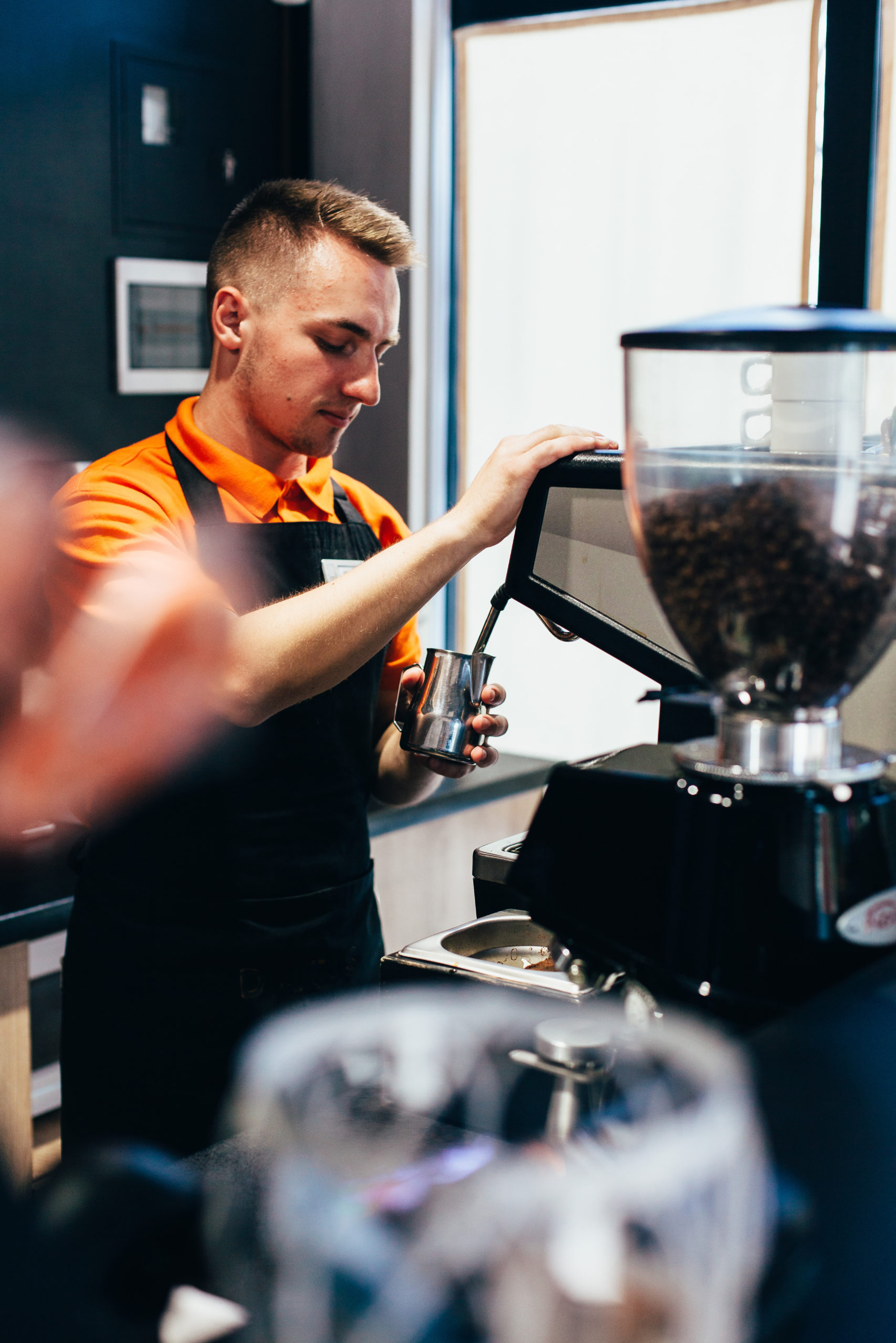 man steaming milk at franchise coffee shop